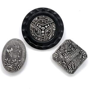 Three black glass buttons with silver luster.