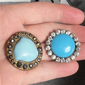 Two blue glass in metal buttons.