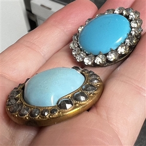 Two blue glass in metal buttons.
