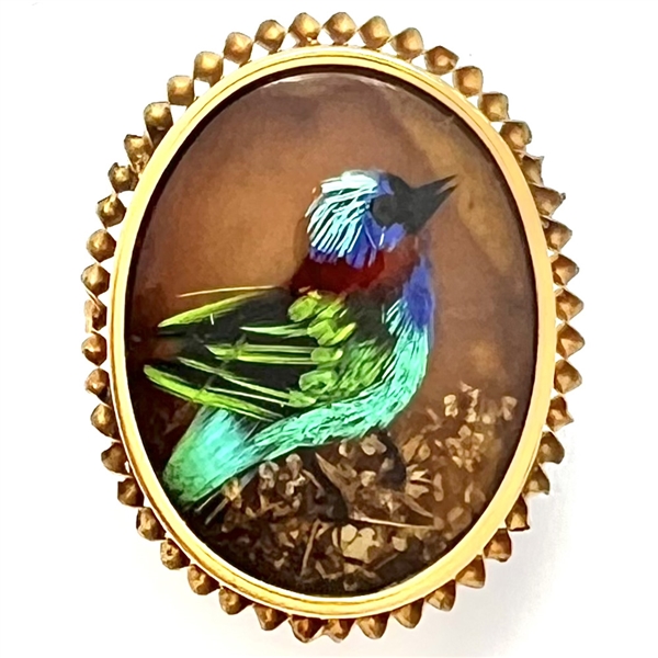 Bird button with real bird feathers over pearl under glass set in metal.