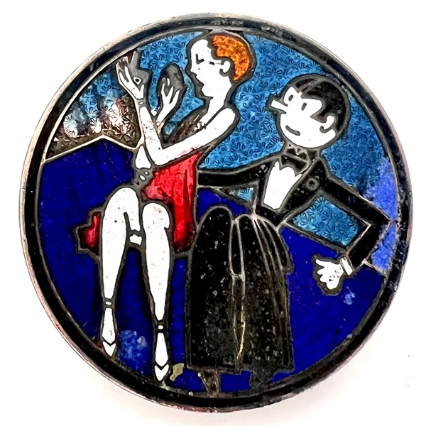 A champlevé enamel button of a 1920s man and woman out on the town.