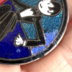 A champlevé enamel button of a 1920's man and woman out on the town.