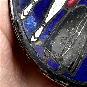A champlevé enamel button of a 1920's man and woman out on the town.
