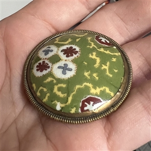Painted porcelain button set in brass of patterns.
