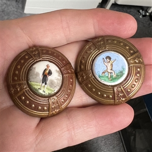 Two painted porcelain buttons set in brass.