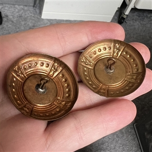 Two painted porcelain buttons set in brass.