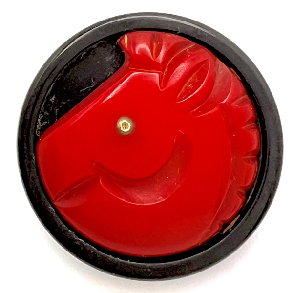 Bakelite button of a horse with metal eye.
