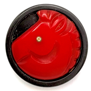 Bakelite button of a horse with metal eye.