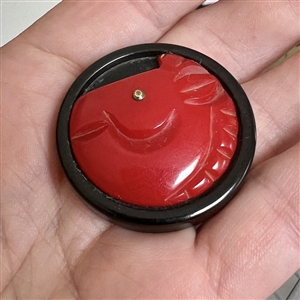 Bakelite button of a horse with metal eye.