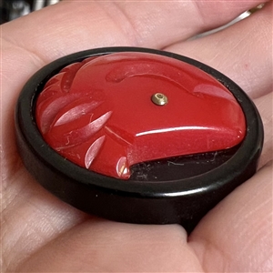 Bakelite button of a horse with metal eye.