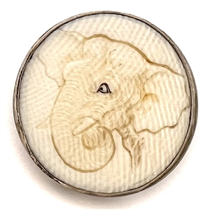 Carved natural material of an elephant head set in silver.