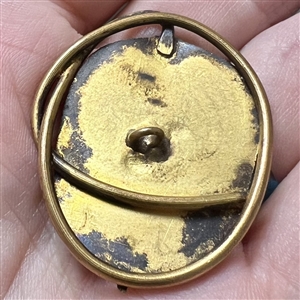 Arts and Crafts metal button of a stylized leaf.