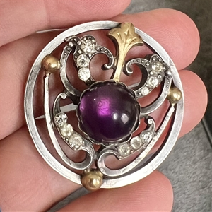 Arts and Crafts button of gilded and silvered metal with amethyst glass center.