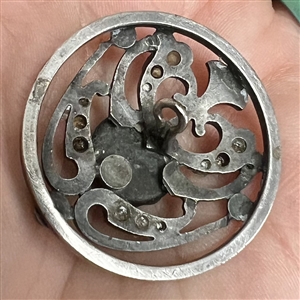 Arts and Crafts button of gilded and silvered metal with amethyst glass center.