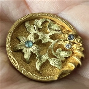 UNUSUAL heavily gilded metal button of flowers with aqua pastes.