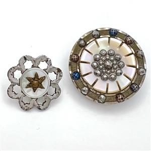 Two steel and pearl buttons.