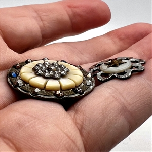 Two steel and pearl buttons.