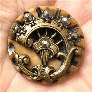 Brass escutcheon and cut-steels over carved vegetable ivory button.