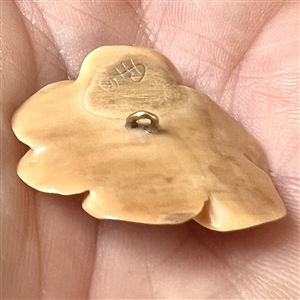 Carved fossilized natural material button of realistic flower with real gold center. 