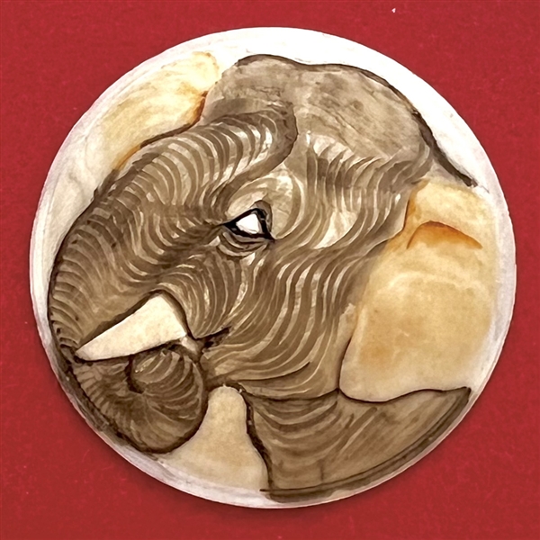 Carved natural material button of an elephant.