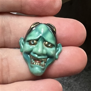 Realistic porcelain Arita Noh theater mask button.