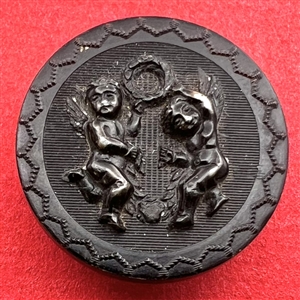 Horn button of cherubs dancing with a laurel wreath.