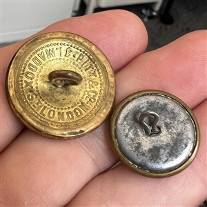 Two brass buttons - a crow work clothes and a livery crest of two birds fighting.