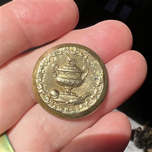 Gilded brass sporting button of a sporting awards cup.