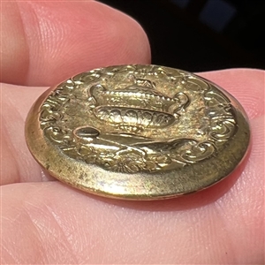 Gilded brass sporting button of a sporting awards cup.