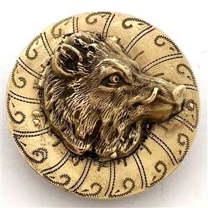 Brass button of a boars head over a pattern.