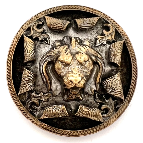 Brass button of a lions head bursting through.