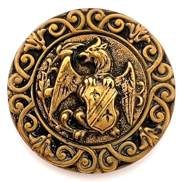 Brass button of a creature holding a shield. 