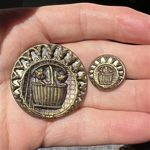 Two brass button of “kittens in a basket in mother daughter sizes.