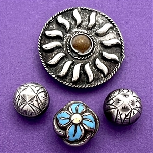 Four assorted Mexican and Native American silver buttons.