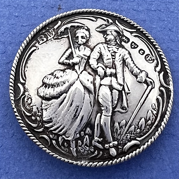 Hallmarked silver button of man and woman walking with umbrella and cane. 