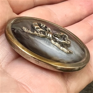 A 19th c. Iridescent pearl button with silvered brass bow.