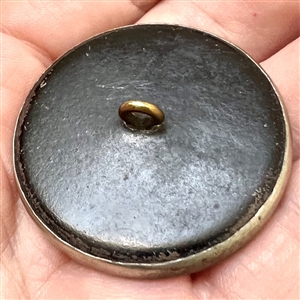 A 19th c. Iridescent pearl button with silvered brass bow.