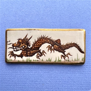 Huge painted ceramic studio button by Stella Rzanski of a dragon. 