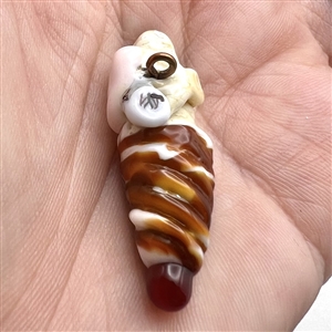 Mary Gaumond's torch-worked glass studio button of a twist ice cream cone held by a hand.