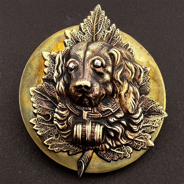 Extra large brass button with an escutcheon of a St. Bernard dog over a leaf.