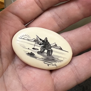 Scrimshaw button of an Eskimo ice fishing.