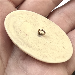 Scrimshaw button of an Eskimo ice fishing.