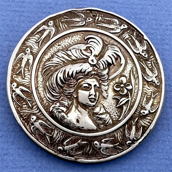 Silvered brass button of Lillian Russel with swallow border.