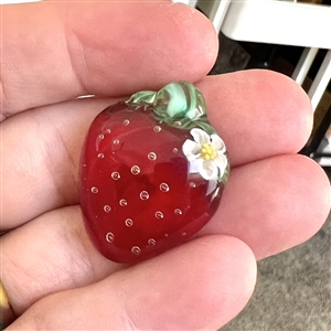 Mary Gaumond's torch-worked glass studio button of a realistic strawberry.