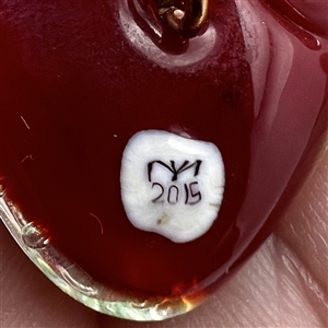 Mary Gaumond's torch-worked glass studio button of a realistic strawberry.
