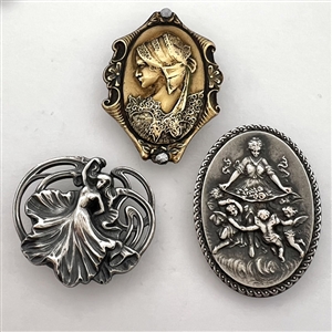 Three stamped metal buttons of women.