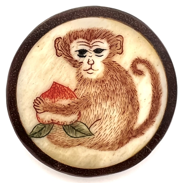 Natural material button of a monkey with a turnip set in boxwood.