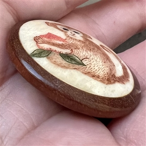 Natural material button of a monkey with a turnip set in boxwood.