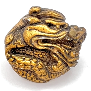 Painted plaster button of a dragon head.