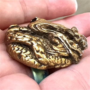 Painted plaster button of a dragon head.